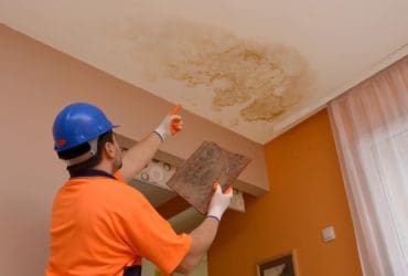 construction worker points to the place where the leaked water