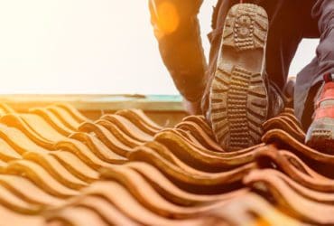 roofer climbing tile roof