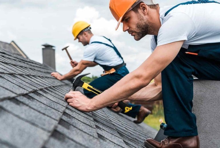 Roofing contractors installing tile roof onto a home