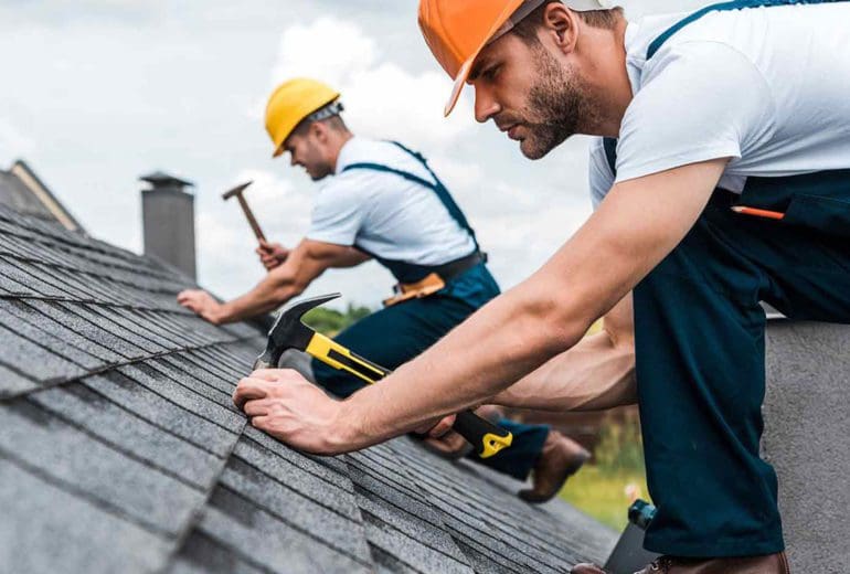 Two male contractors, installing a grey roof