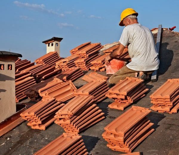 Roofer surrounded by roofing materials