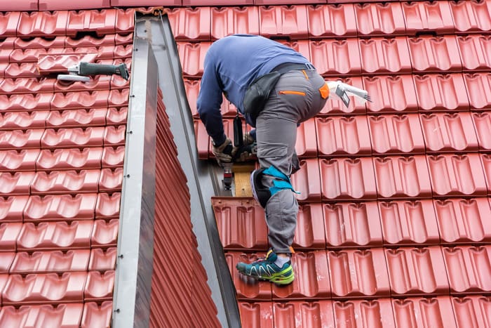 Roofer repair the roof of clay tiles