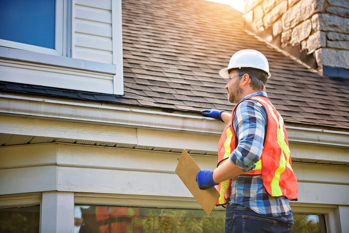 roofer inspecting house roof