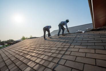 Two roofing experts on roof working on new roof installation
