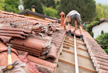 Roofing expert inspecting and repairing a residential roof