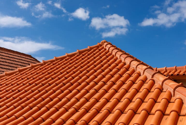 Red tiles panels roof under blue sky on a house