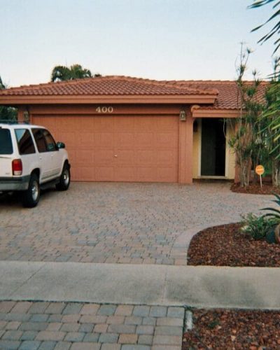 beautiful home car parked outside with surrounded palm trees